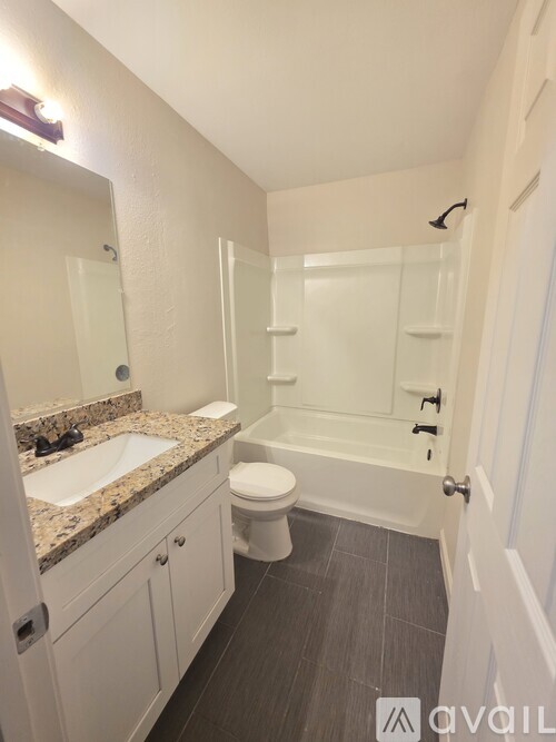 A bathroom with a sink, toilet, and bathtub.