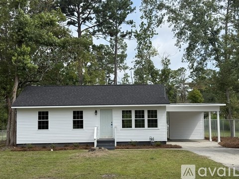 A white house with a black roof and a garage door.