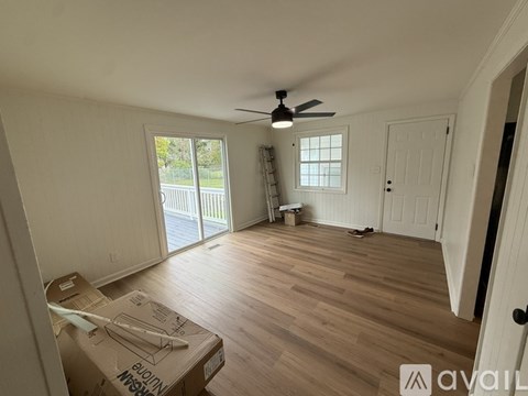 A room with a ceiling fan and wooden flooring.