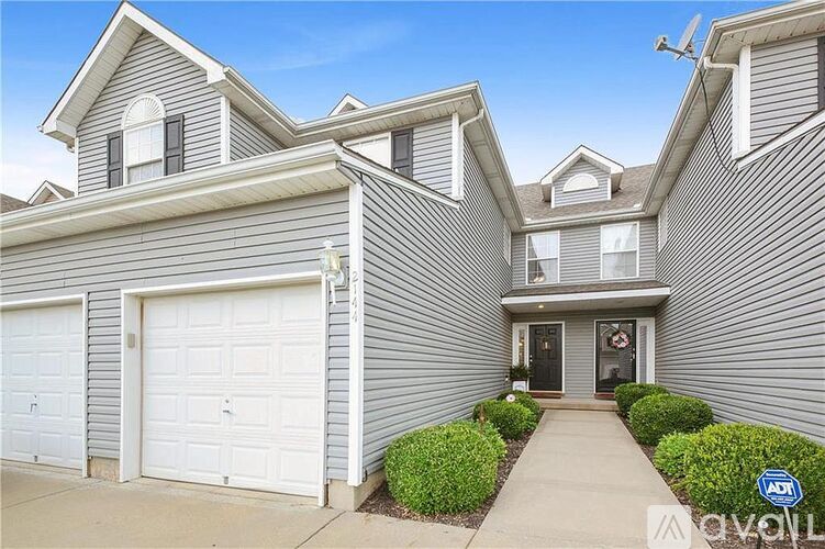 A two-story house with a garage and a driveway.