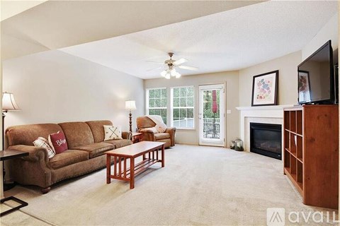 A living room with a brown couch, a coffee table, a fireplace, and a television.