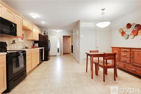 A kitchen with wooden cabinets and black appliances.