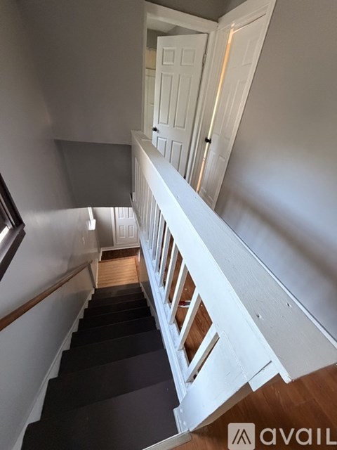 A staircase with a white railing and black steps.
