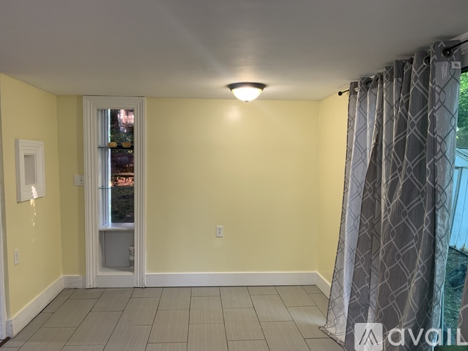 A room with yellow walls and a window with a view of trees outside.