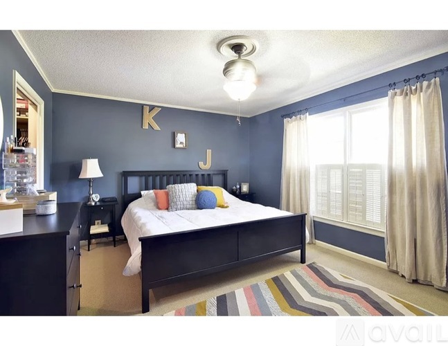 A bedroom with a bed, nightstand, and lamp.