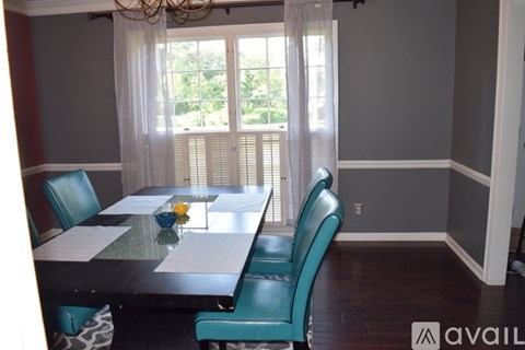 A dining room with a table and chairs.