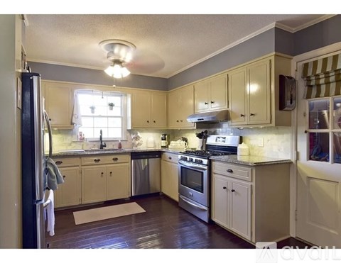 A kitchen with wooden floors and white cabinets.