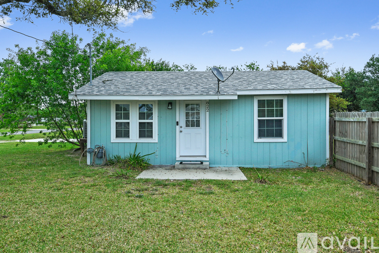 A small blue house with a white door and a small porch.