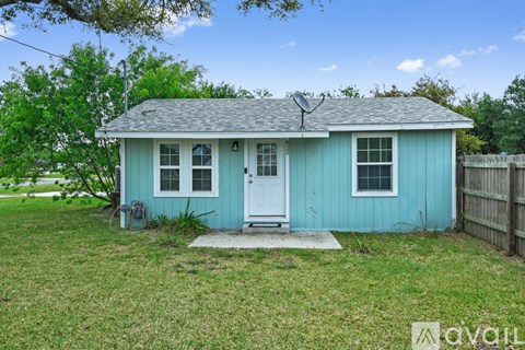 A small blue house with a white door and a small porch.