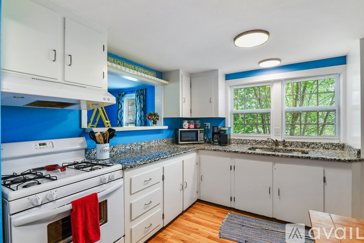 A kitchen with white cabinets and a blue backsplash.