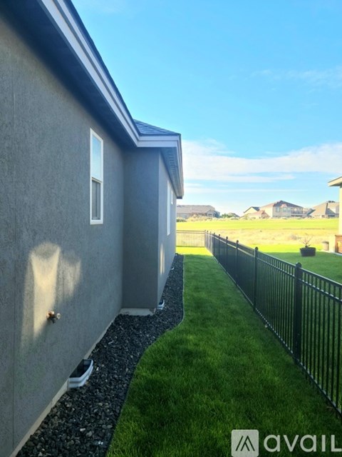 A house with a grey exterior and a black fence.