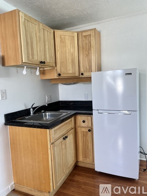 A kitchen with wooden cabinets and a white fridge.