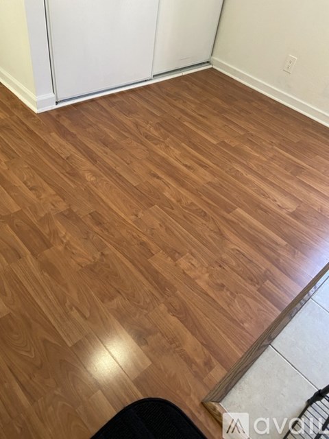 A room with wooden flooring and white walls.