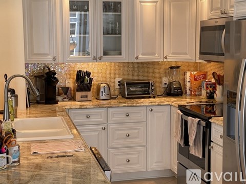 A kitchen with white cabinets and a tiled backsplash.