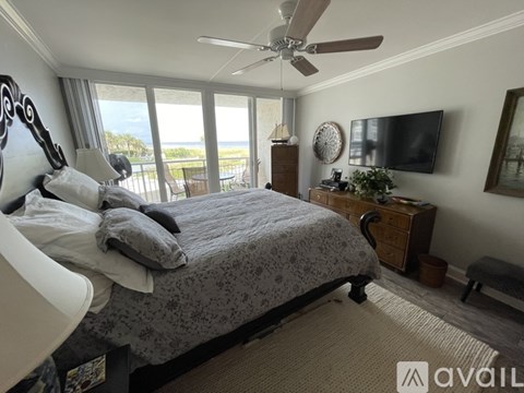 A bedroom with a large bed and a flat screen TV mounted on the wall.