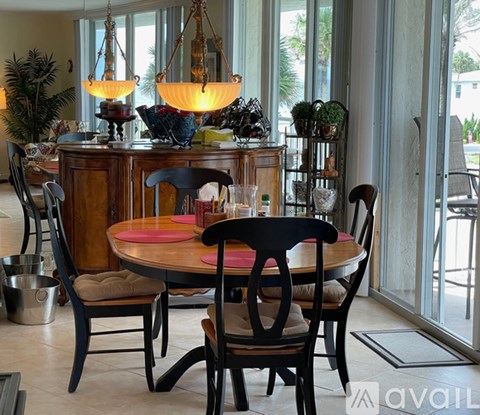 A dining room with a round table and chairs.