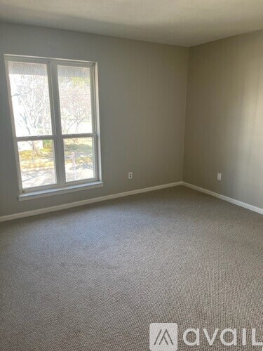 A room with a carpeted floor and a window.