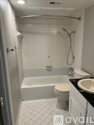 A white bathroom with a toilet, sink, and bathtub.