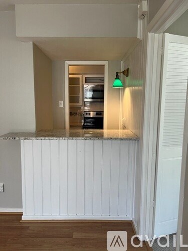 A kitchen with a white counter and cabinets.