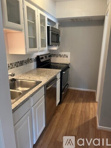A kitchen with white cabinets and a granite countertop.