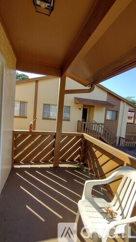 A patio with a white chair and a table.