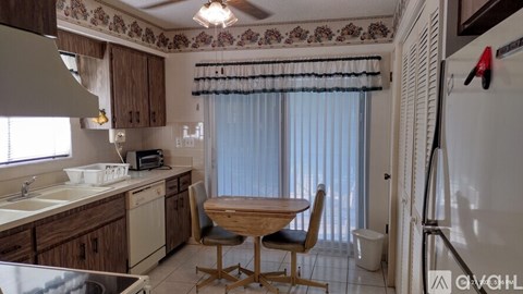 A kitchen with a table and chairs in front of a window.
