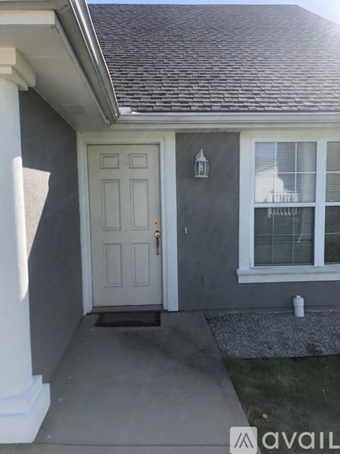 A house with a white door and a grey wall.