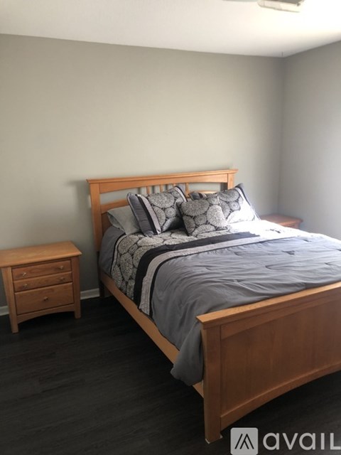 A bedroom with a bed, nightstand, and a wall-mounted air conditioner.