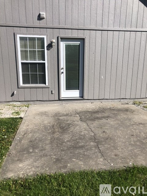 A grey building with a white door and window.