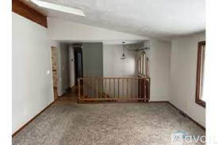 A room with a carpeted floor and a wooden gate.