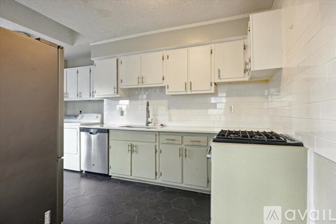 A kitchen with white cabinets and a black stove top.