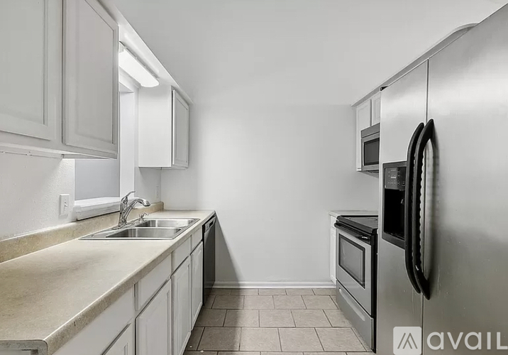 A kitchen with a sink, stove, and cabinets.