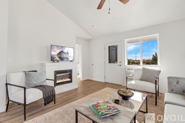 A living room with a fireplace, a chair, a sofa, a coffee table, and a painting on the wall.