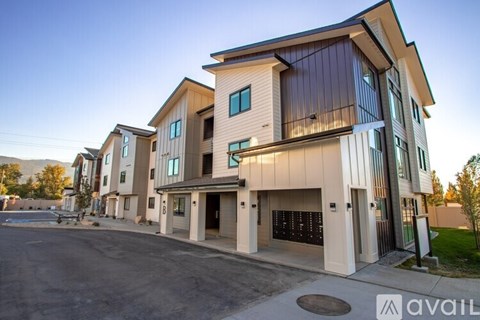 A modern multi-story building with a parking lot in front.