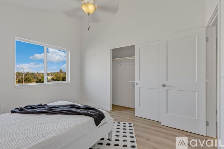A bedroom with a large bed and a window overlooking a landscape.