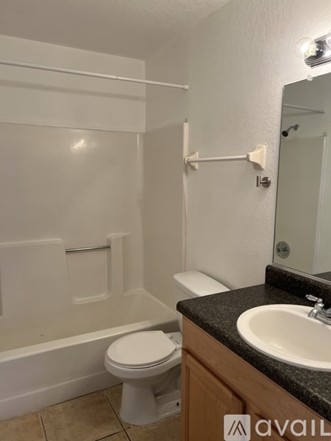 A bathroom with a toilet, sink, and bathtub.