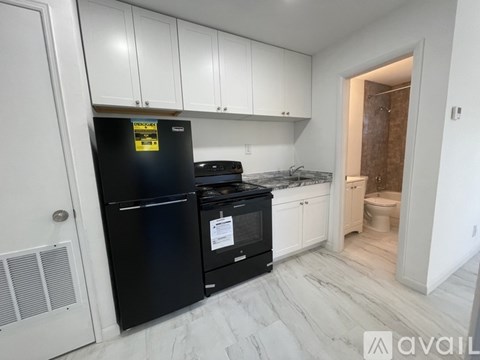 A kitchen with black appliances and white cabinets.
