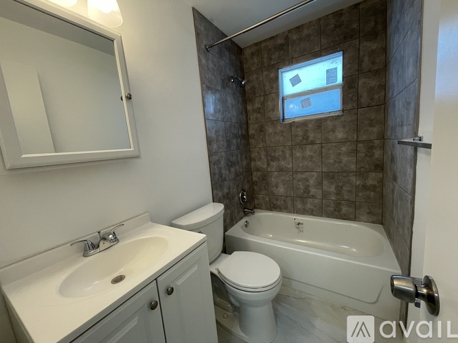 A bathroom with a white toilet, sink, and bathtub.