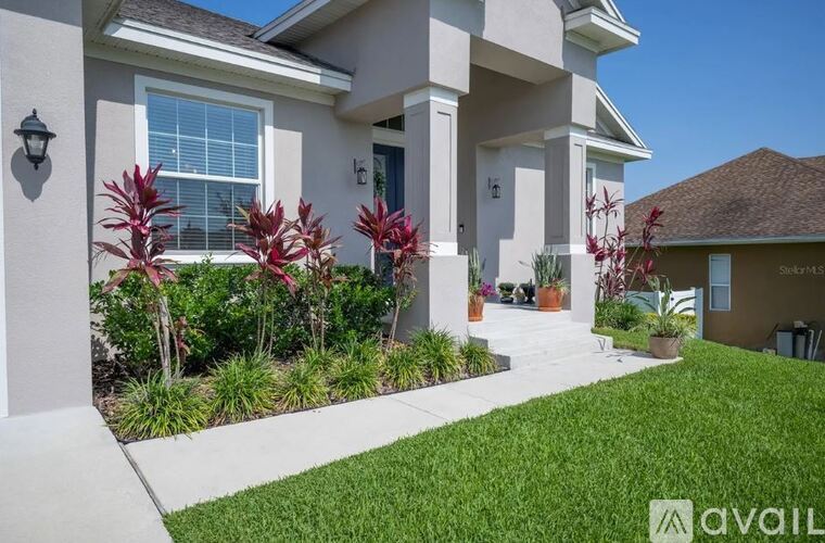 A house with a well-maintained lawn and landscaping in front.