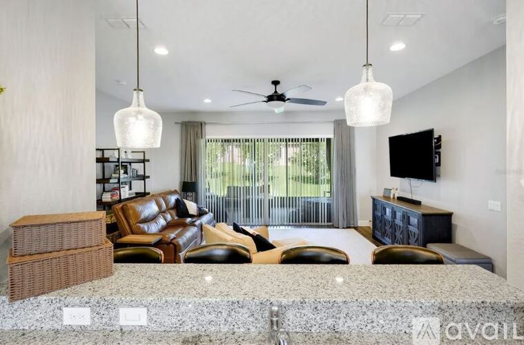 A spacious living room with a large couch and a television on the wall.