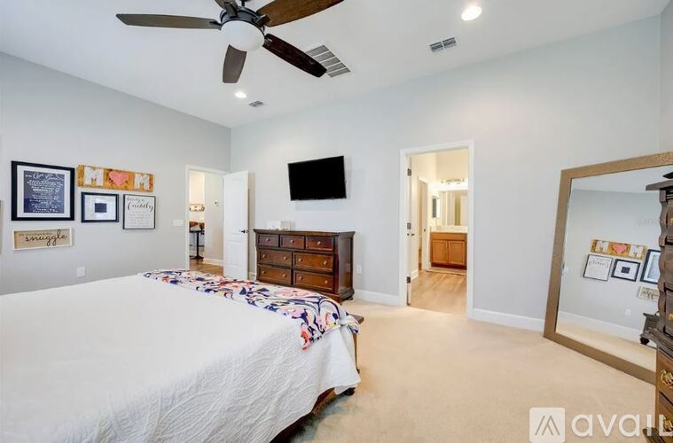 A bedroom with a bed, dresser, and mirror.