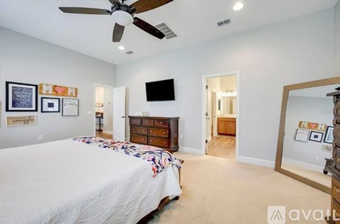 A bedroom with a bed, dresser, and mirror.