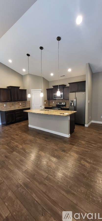 A kitchen with wooden floors and a large island in the middle.