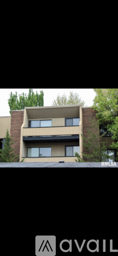 A building with a beige facade and a tree in front of it.
