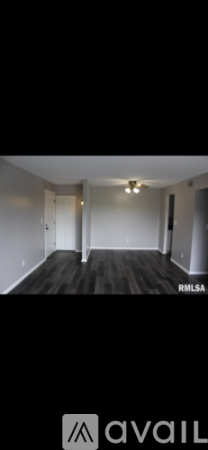 A room with wooden flooring and white walls.