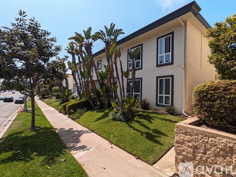 A house with a well-maintained lawn and a sidewalk in front.