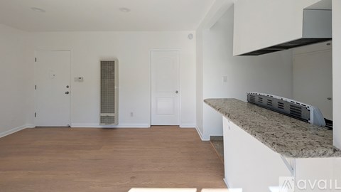 A spacious, empty room with a counter and cabinets on the right.
