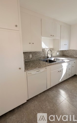A kitchen with white cabinets and a granite countertop.