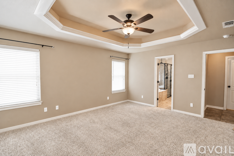 A spacious room with a ceiling fan and a window with blinds.