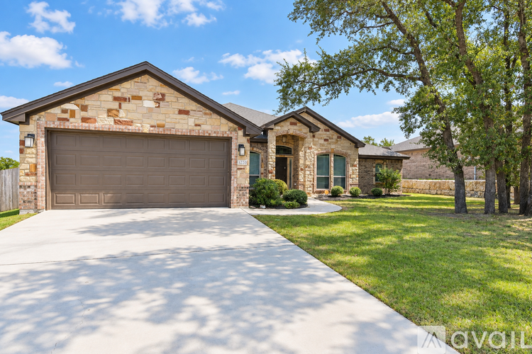 A house with a garage and a driveway in front of it.
